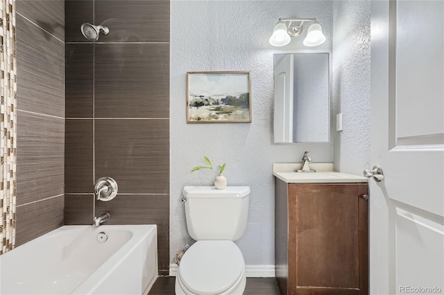 bathroom with a textured wall, toilet, vanity, baseboards, and tub / shower combination