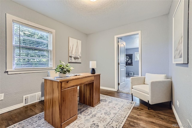 office space featuring baseboards, a textured ceiling, visible vents, and dark wood-style flooring