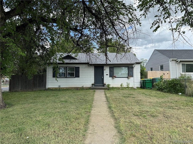 view of front of home with fence and a front lawn