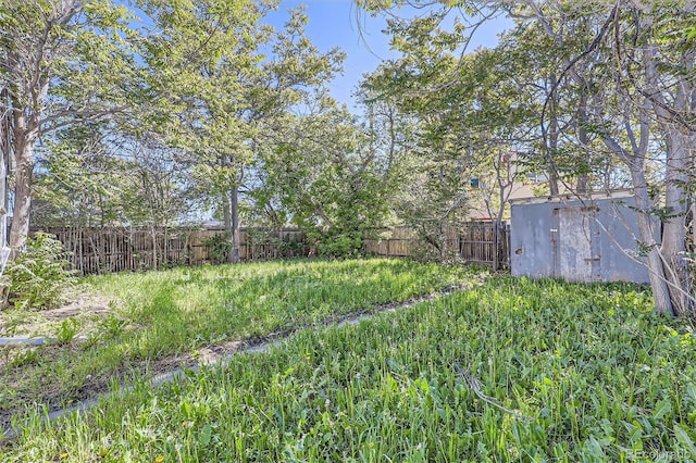 view of yard featuring fence and an outdoor structure