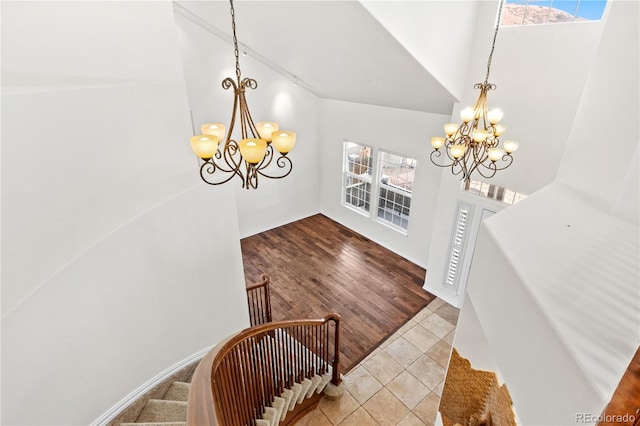 tiled foyer entrance featuring high vaulted ceiling and a notable chandelier