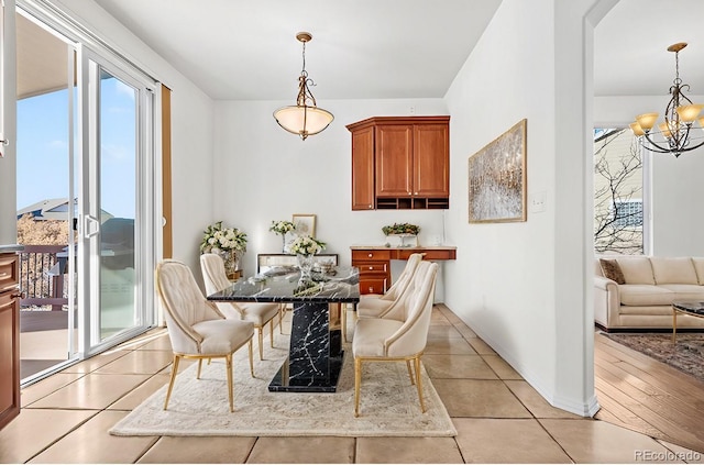 dining space featuring light tile patterned floors and an inviting chandelier