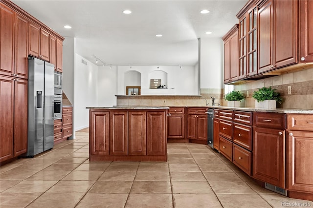 kitchen with tasteful backsplash, a center island, light tile patterned flooring, and appliances with stainless steel finishes