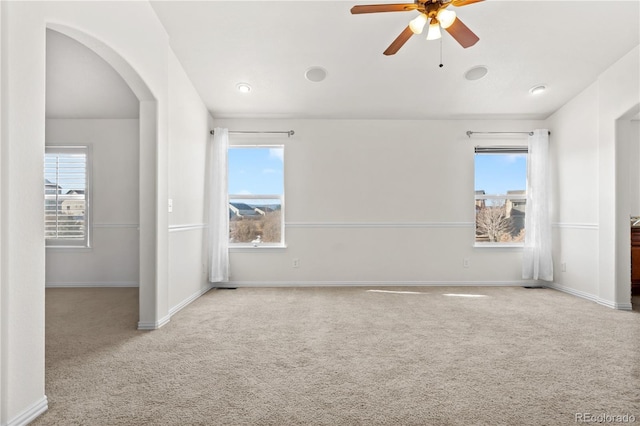 unfurnished bedroom with multiple windows, ceiling fan, and light colored carpet