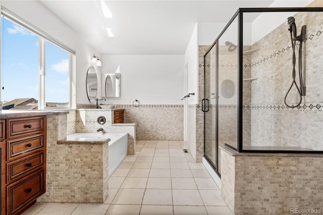 bathroom with tile patterned floors, vanity, separate shower and tub, and tile walls