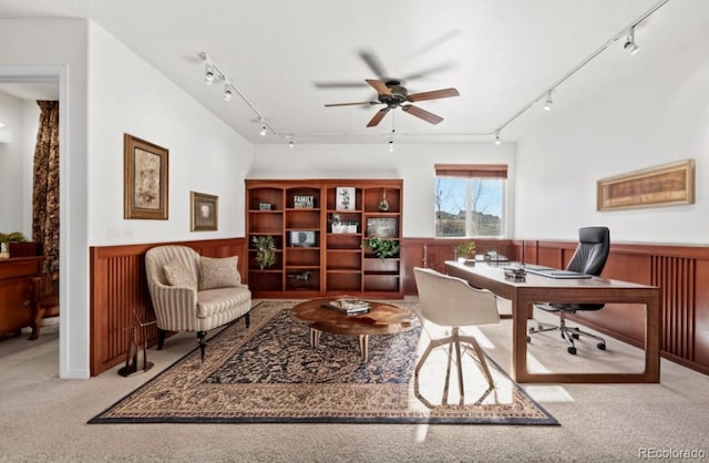 carpeted office with wood walls and ceiling fan