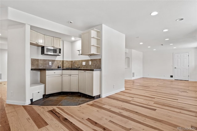 kitchen with dark hardwood / wood-style flooring, white cabinetry, sink, and tasteful backsplash