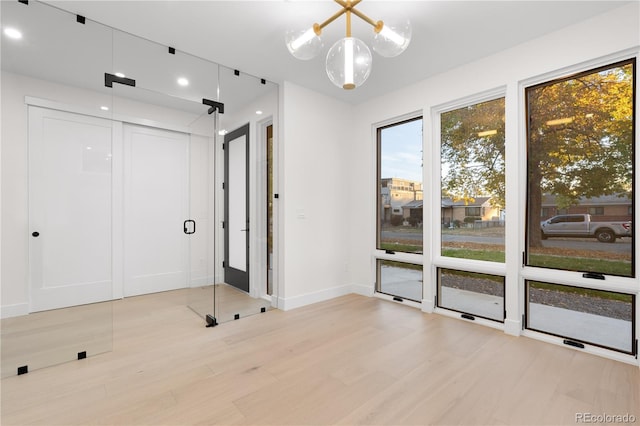 unfurnished room with light hardwood / wood-style flooring and a chandelier