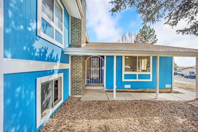 view of front of property with crawl space, brick siding, and a carport