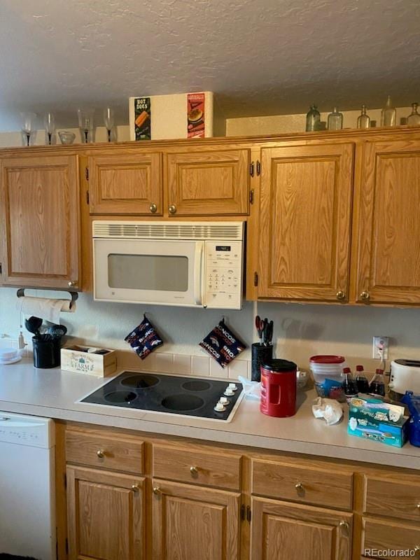 kitchen with white appliances and a textured ceiling