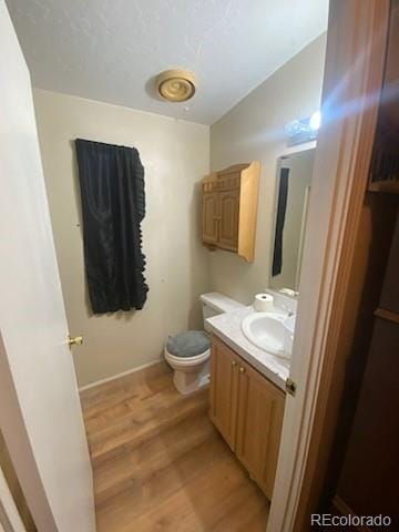 bathroom featuring hardwood / wood-style floors, vanity, and toilet