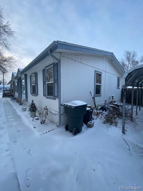 view of snow covered exterior featuring a carport