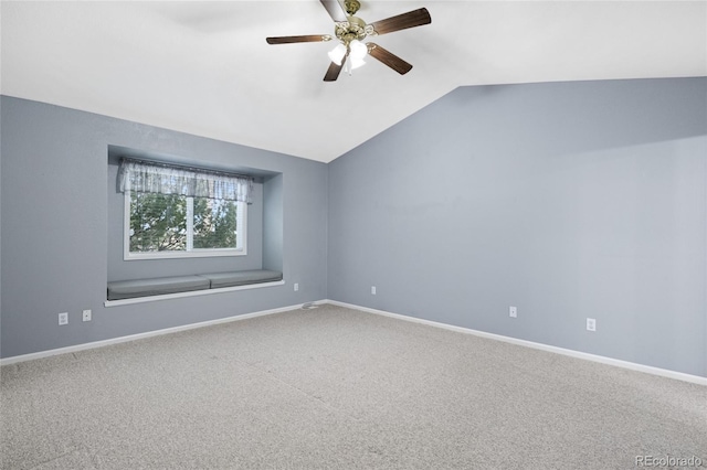 empty room with lofted ceiling, carpet floors, and ceiling fan