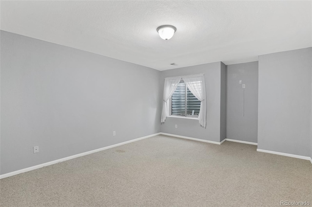 carpeted spare room featuring a textured ceiling