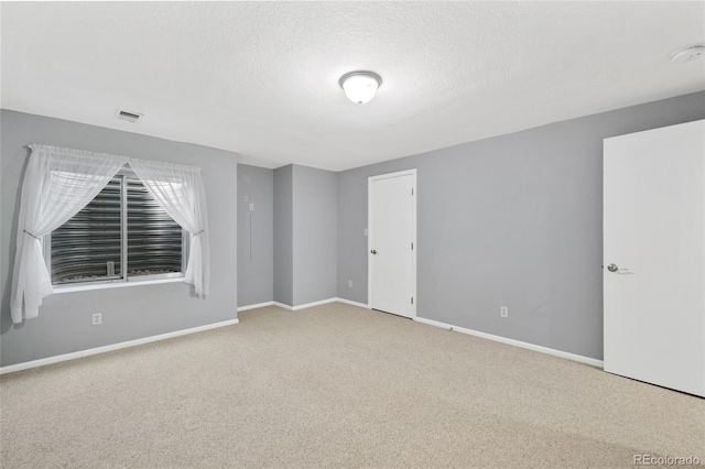 empty room featuring carpet and a textured ceiling