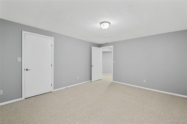 carpeted empty room with a textured ceiling