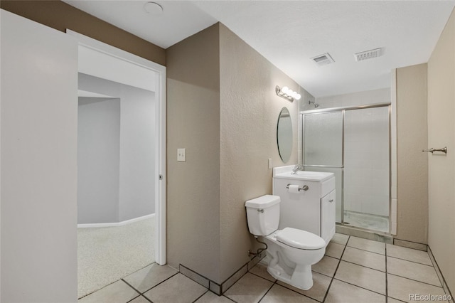 bathroom featuring tile patterned flooring, vanity, a shower with door, and toilet