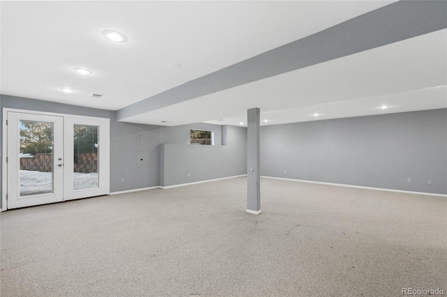 basement featuring french doors and light colored carpet