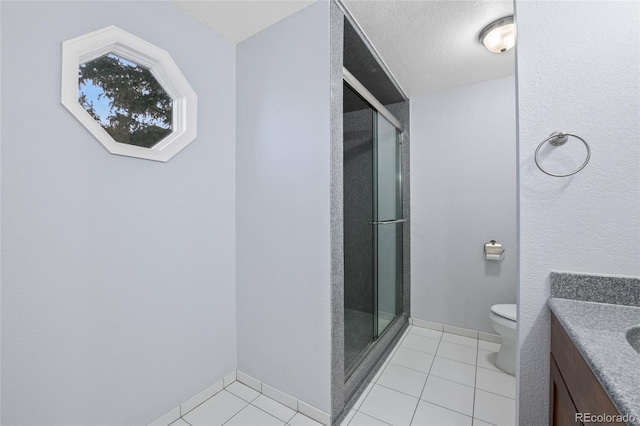 bathroom featuring tile patterned flooring, a stall shower, toilet, and vanity