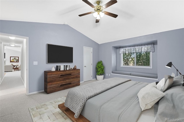 bedroom with vaulted ceiling, light colored carpet, baseboards, and ceiling fan