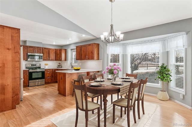 dining space featuring baseboards, a chandelier, vaulted ceiling, recessed lighting, and light wood-style floors