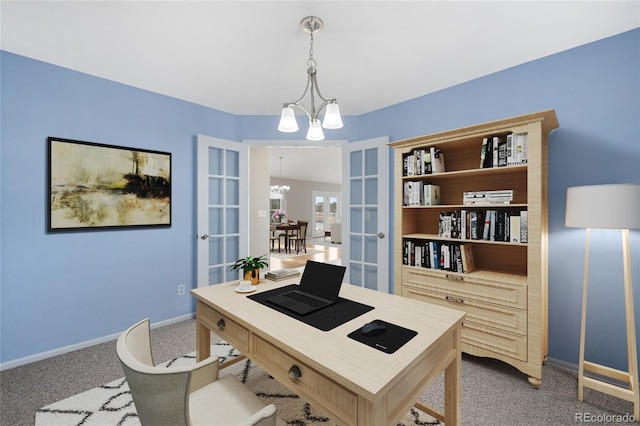 carpeted office space with a notable chandelier, french doors, and baseboards