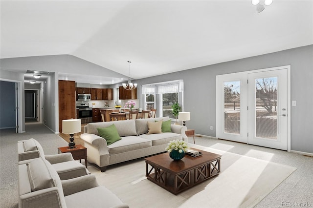 living area with vaulted ceiling, light colored carpet, baseboards, and a chandelier