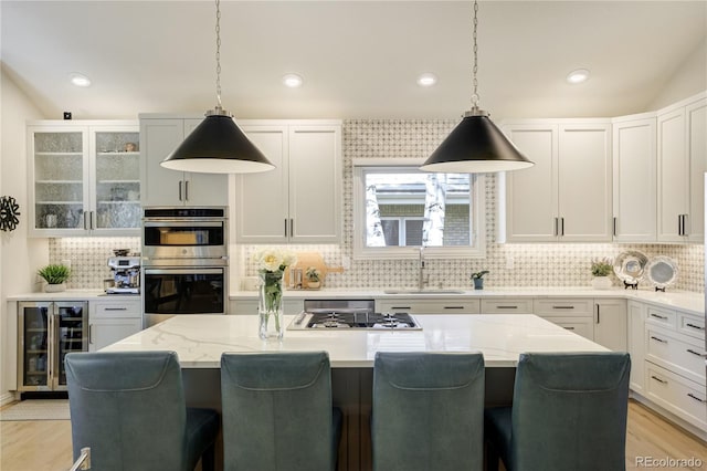 74 Blue Heron Dr, Greenwood Village, CO 80121 - kitchen featuring wine cooler, appliances with stainless steel finishes, backsplash, a breakfast bar area, and recessed lighting