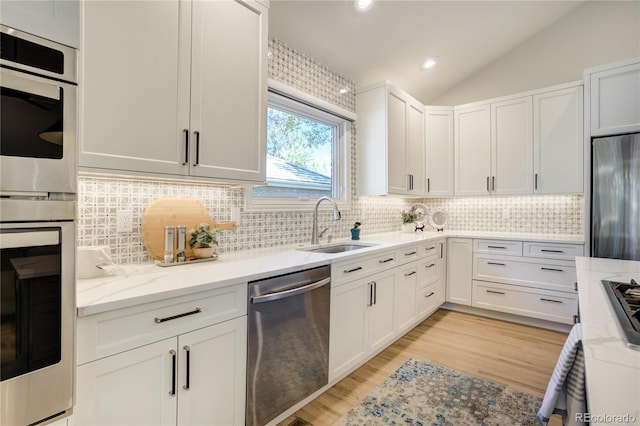 74 Blue Heron Dr, Greenwood Village, CO 80121 - kitchen with stainless steel appliances, backsplash, light stone counters, lofted ceiling, and recessed lighting