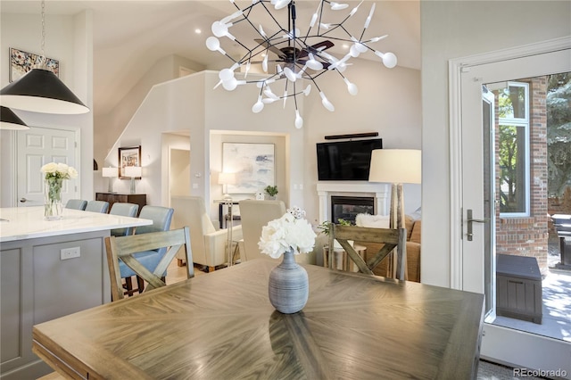 74 Blue Heron Dr, Greenwood Village, CO 80121 - dining area featuring a chandelier, a glass covered fireplace, and vaulted ceiling