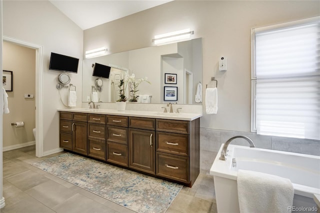 74 Blue Heron Dr, Greenwood Village, CO 80121 - full bath featuring a tub to relax in, double vanity, tile patterned floors, and vaulted ceiling