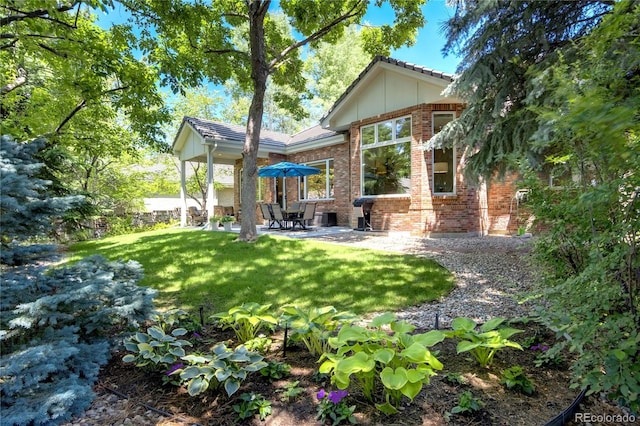 74 Blue Heron Dr, Greenwood Village, CO 80121 - back of property featuring brick siding, a patio area, and a lawn
