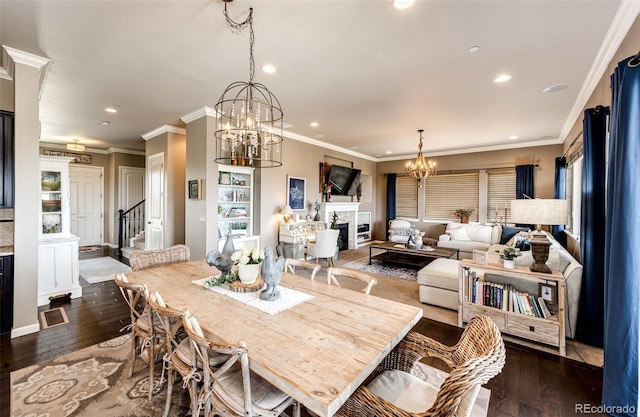 2115 Holmby Ct, Castle Rock, CO 80104 - dining area featuring a fireplace, a chandelier, dark wood-style floors, recessed lighting, and crown molding