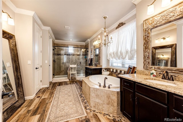 2115 Holmby Ct, Castle Rock, CO 80104 - full bathroom with a garden tub, a stall shower, two vanities, crown molding, and a chandelier