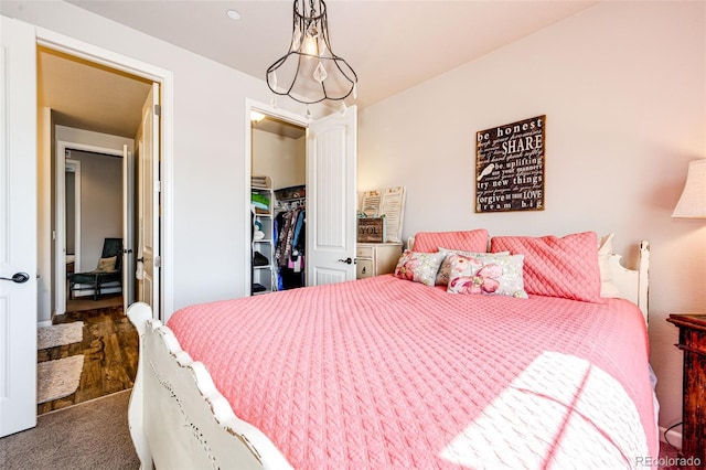 2115 Holmby Ct, Castle Rock, CO 80104 - bedroom featuring a walk in closet, a closet, and dark colored carpet