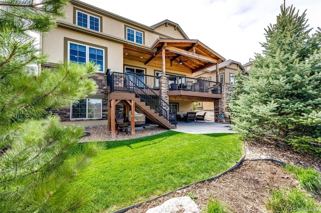 2115 Holmby Ct, Castle Rock, CO 80104 - rear view of house featuring stucco siding, stairway, a patio, a lawn, and a wooden deck