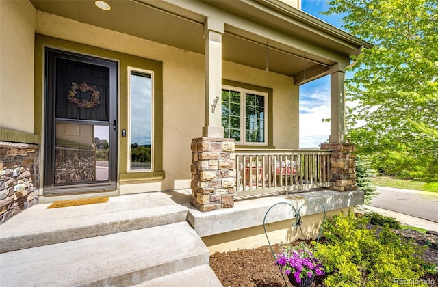 2115 Holmby Ct, Castle Rock, CO 80104 - entrance to property with covered porch, stucco siding, and stone siding