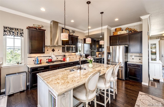 2115 Holmby Ct, Castle Rock, CO 80104 - kitchen featuring appliances with stainless steel finishes, wall chimney range hood, a sink, dark brown cabinetry, and decorative backsplash