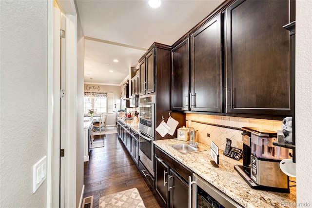 2115 Holmby Ct, Castle Rock, CO 80104 - kitchen featuring a sink, dark brown cabinetry, light stone counters, backsplash, and recessed lighting