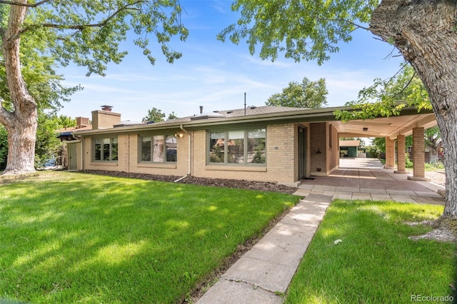 1637 S Stuart St, Denver, CO 80219 - view of front of home featuring brick siding, a front yard, and a chimney