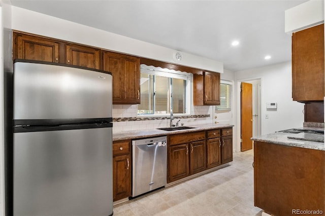1637 S Stuart St, Denver, CO 80219 - kitchen featuring appliances with stainless steel finishes, decorative backsplash, light floors, recessed lighting, and light stone counters