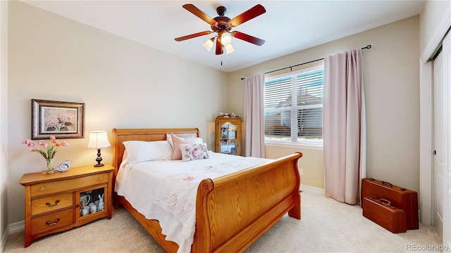 bedroom featuring ceiling fan, light carpet, and a closet