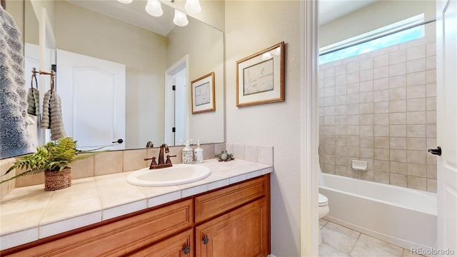 full bathroom with tiled shower / bath combo, vanity, tile patterned flooring, and toilet