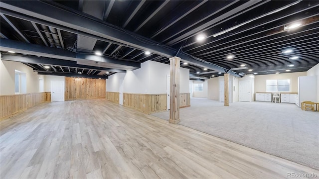 basement featuring wooden walls and light hardwood / wood-style floors