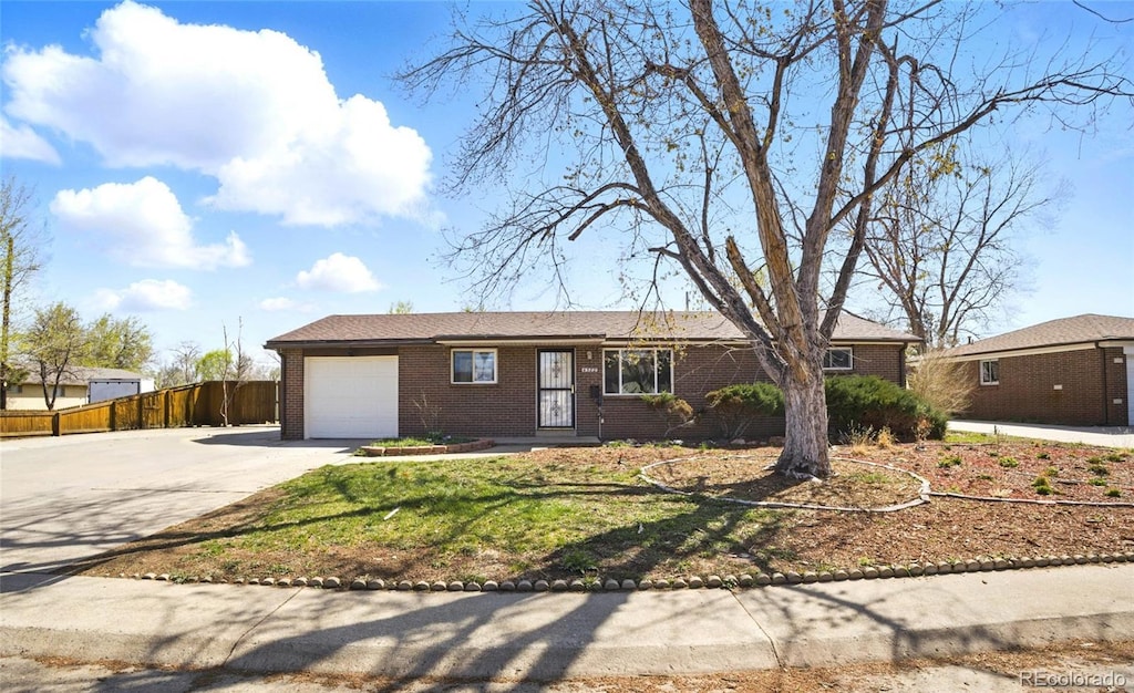 4580 Field St, Wheat Ridge, CO 80033 - ranch-style home with fence, an attached garage, brick siding, and concrete driveway