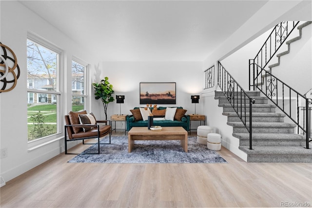 living area with baseboards, stairs, and wood finished floors