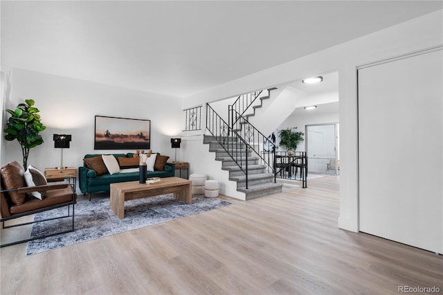 living room with stairway and wood finished floors