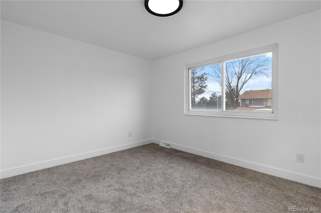 carpeted empty room featuring baseboards and visible vents