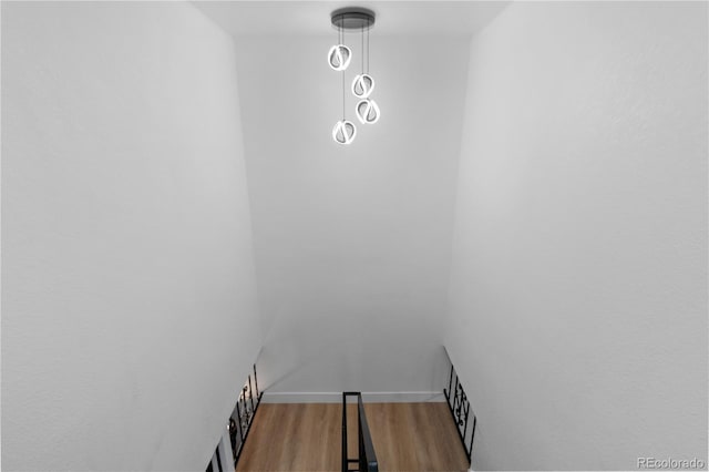 staircase with baseboards and wood finished floors