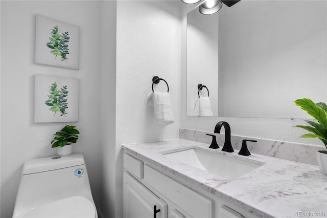 half bath featuring vanity and toilet